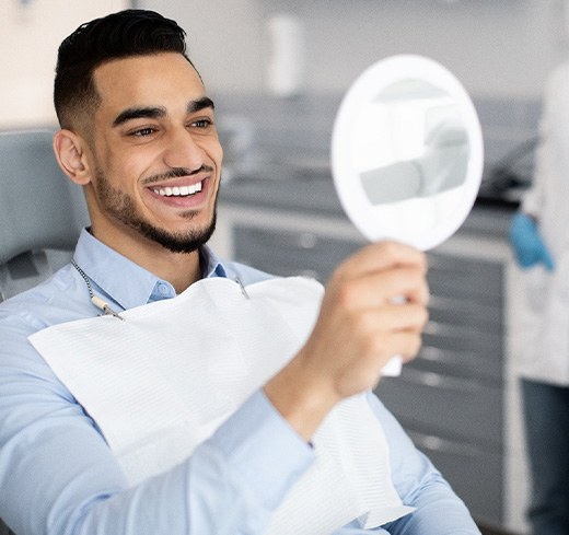 Male patient smiling after learning about dental implant care in Georgetown