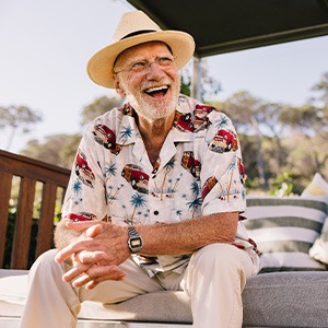 Closeup of man smiling outside on bench