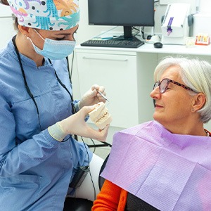 Dentist discussing how dental implants can help a woman save money