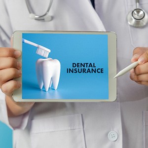 Dentist holding tablet that reads “Dental Insurance”