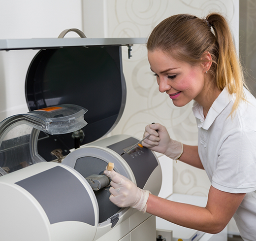 Dentist taking crown out of CEREC machine