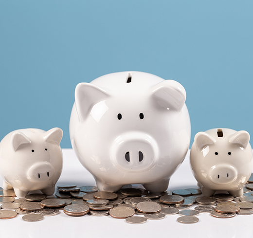 Three piggy banks surrounded by coins
