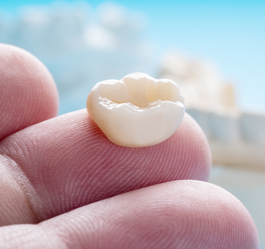 Close up of dental crown on finger