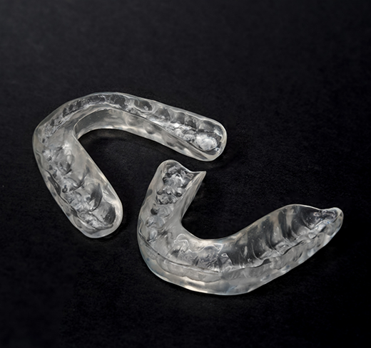 Two nightguards for bruxism on black background