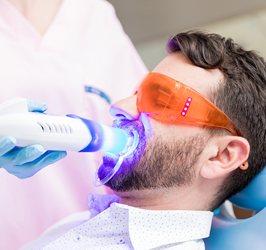 Male patient receiving in-office teeth whitening treatment