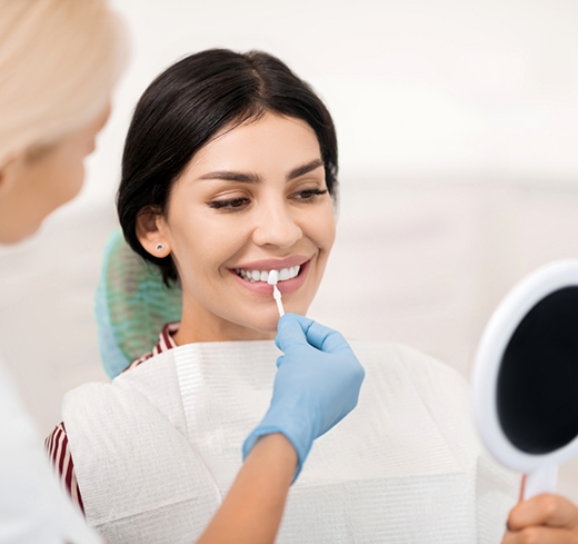 Woman in dental chair having teeth shade matched for veneers