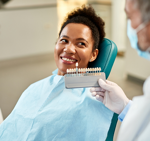 Female patient smiling while having teeth shade matched for veneers