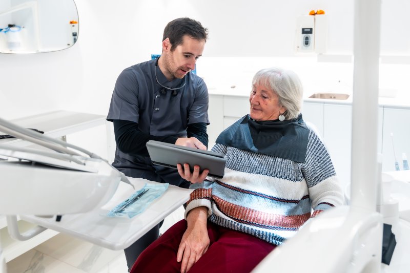 An older woman meeting her dentist for a dental implant consultation